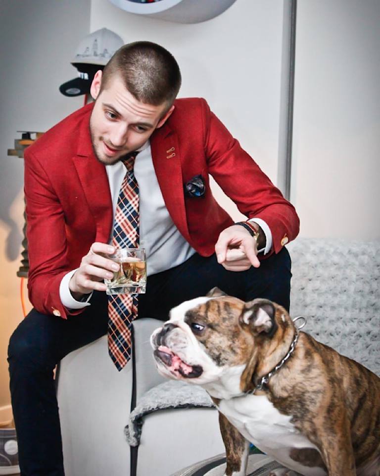 a-man-in-a-red-suit-sitting-with-a-dog